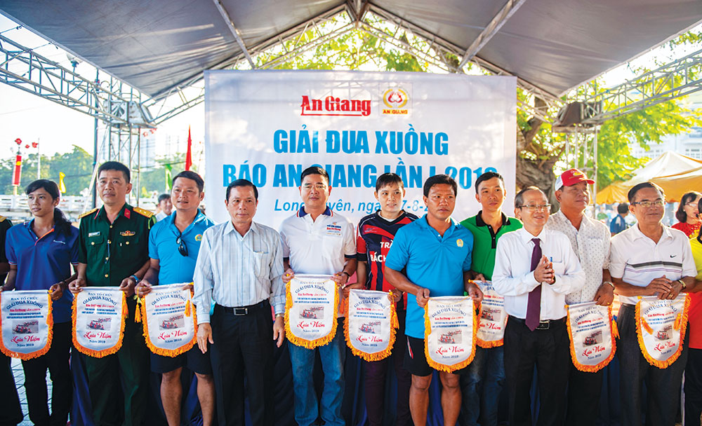 Sôi nổi giải đua xuồng Báo An Giang lần thứ I - 2019 Bí thư Thành ủy, Chủ tịch UBND TP. Long Xuyên Phạm Thành Thái, Phó Tổng Biên tập Báo An Giang Nguyễn Thành Tín trao cờ lưu niệm cho các đội tham dự giải