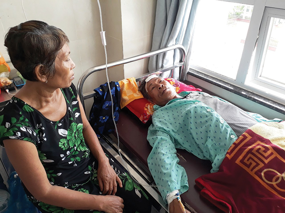 Thương phụ hồ nghèo bị tai nạn lao động Bà Phỉ đang chăm sóc ông Hùng tại bệnh viện