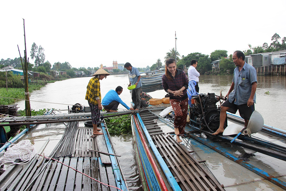Một nông dân ở Chợ Mới dụ nuôi hàng ngàn cá tra sông tự nhiên trước bến sông nhà để ngắm