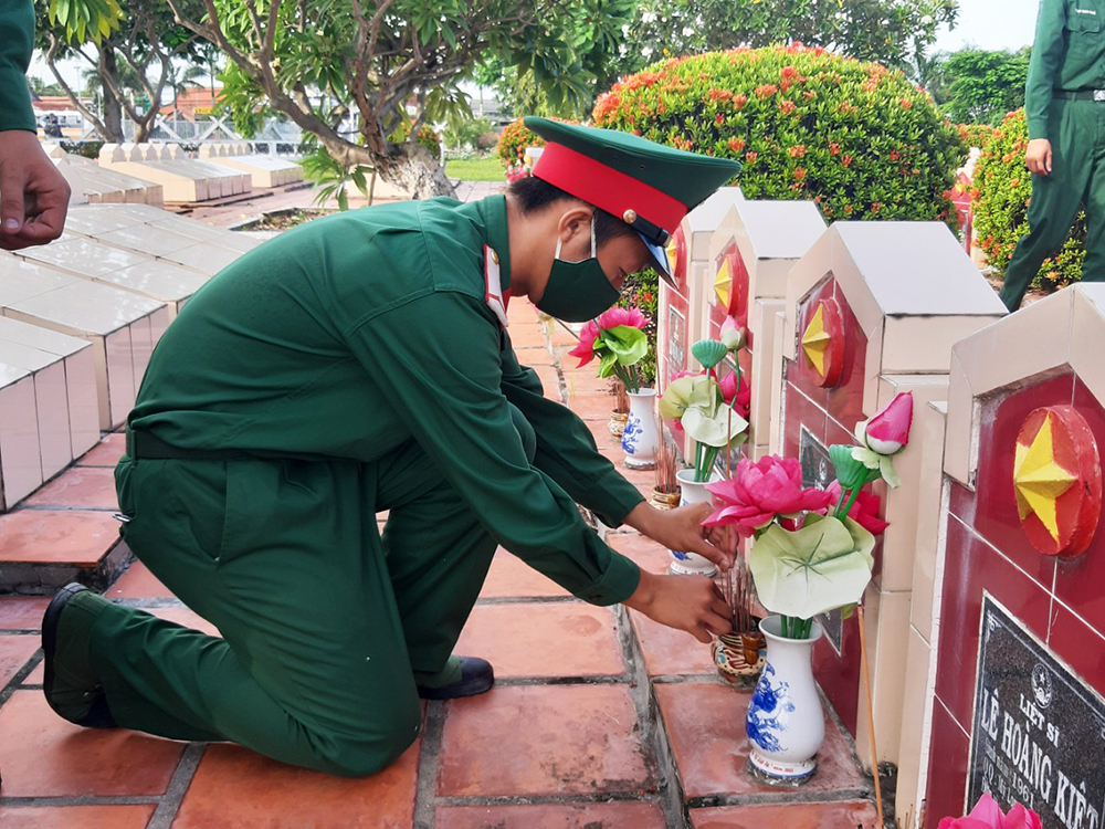 Vệ sinh và thay hoa, lọ hoa ở các phần mộ tại Nghĩa trang Liệt sĩ An Giang