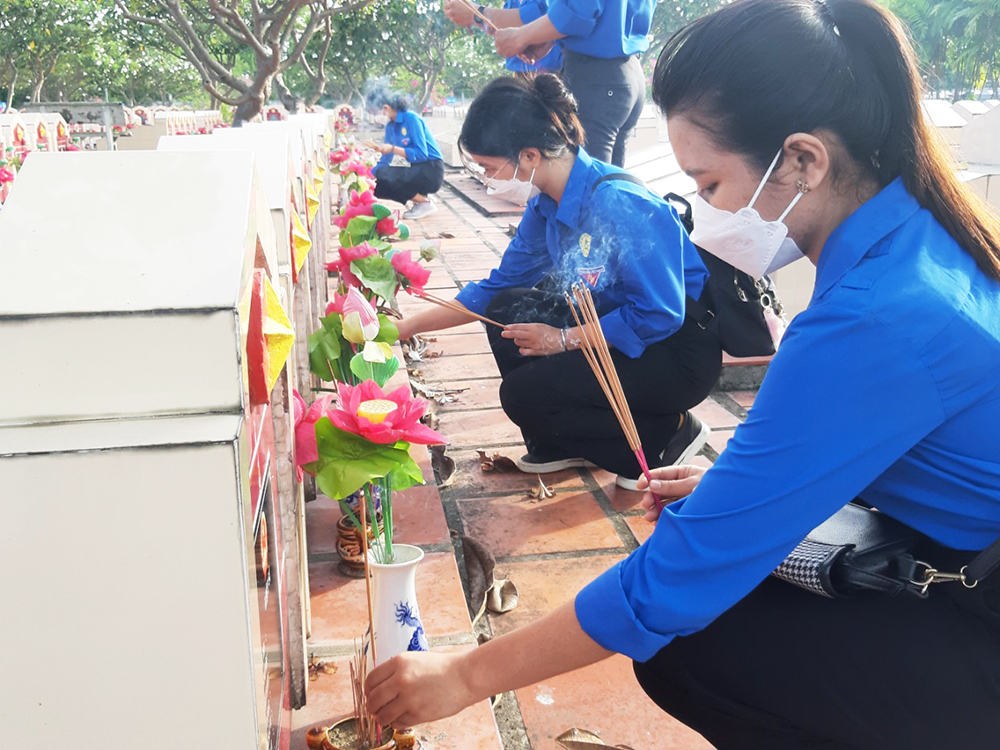 Vệ sinh và thay hoa, lọ hoa ở các phần mộ tại Nghĩa trang Liệt sĩ An Giang
